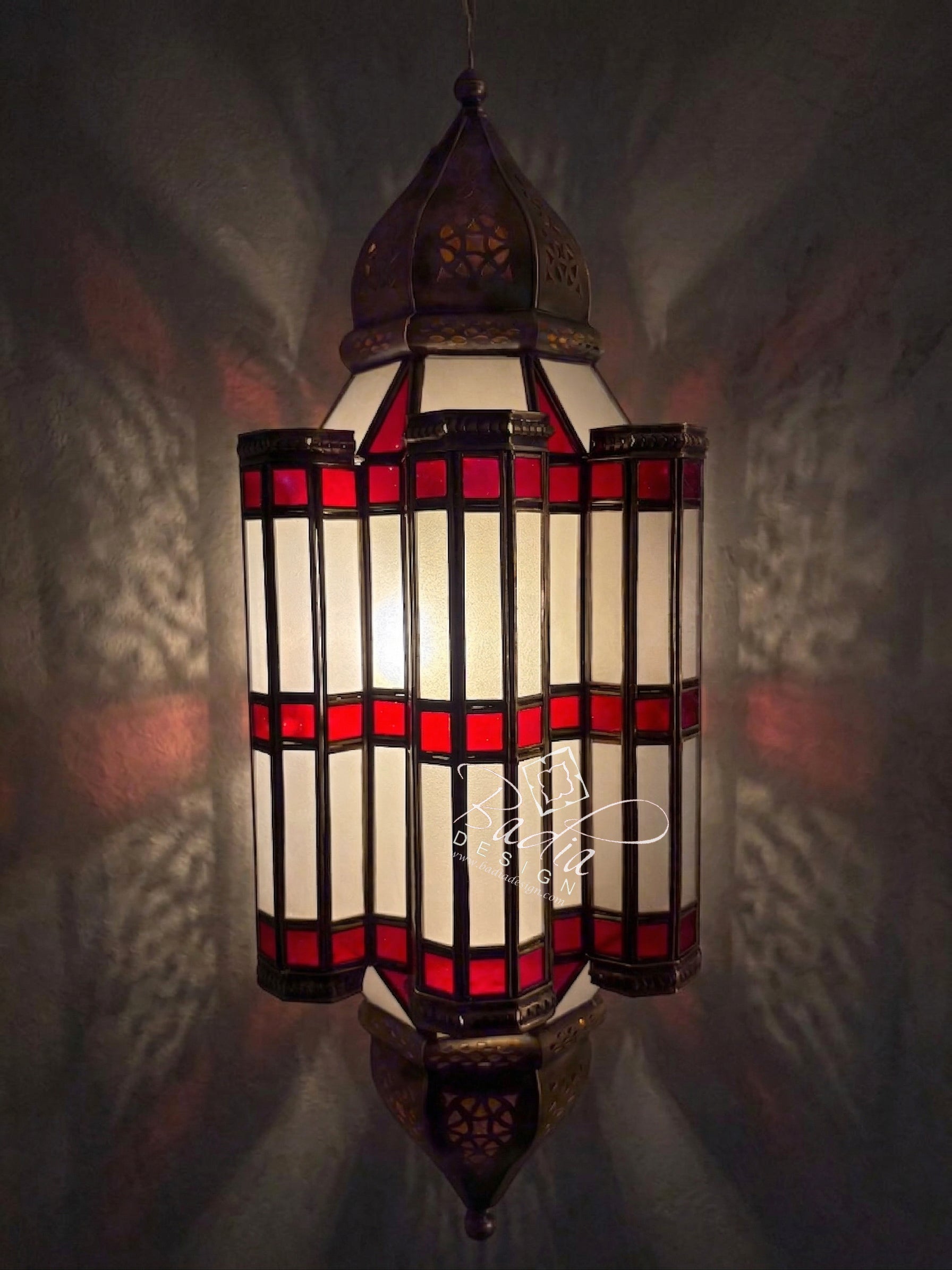 Decorative stained glass lamp with red and white design on a dark background