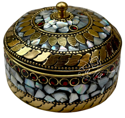 Decorative round box with gold and gemstone details on a white background
