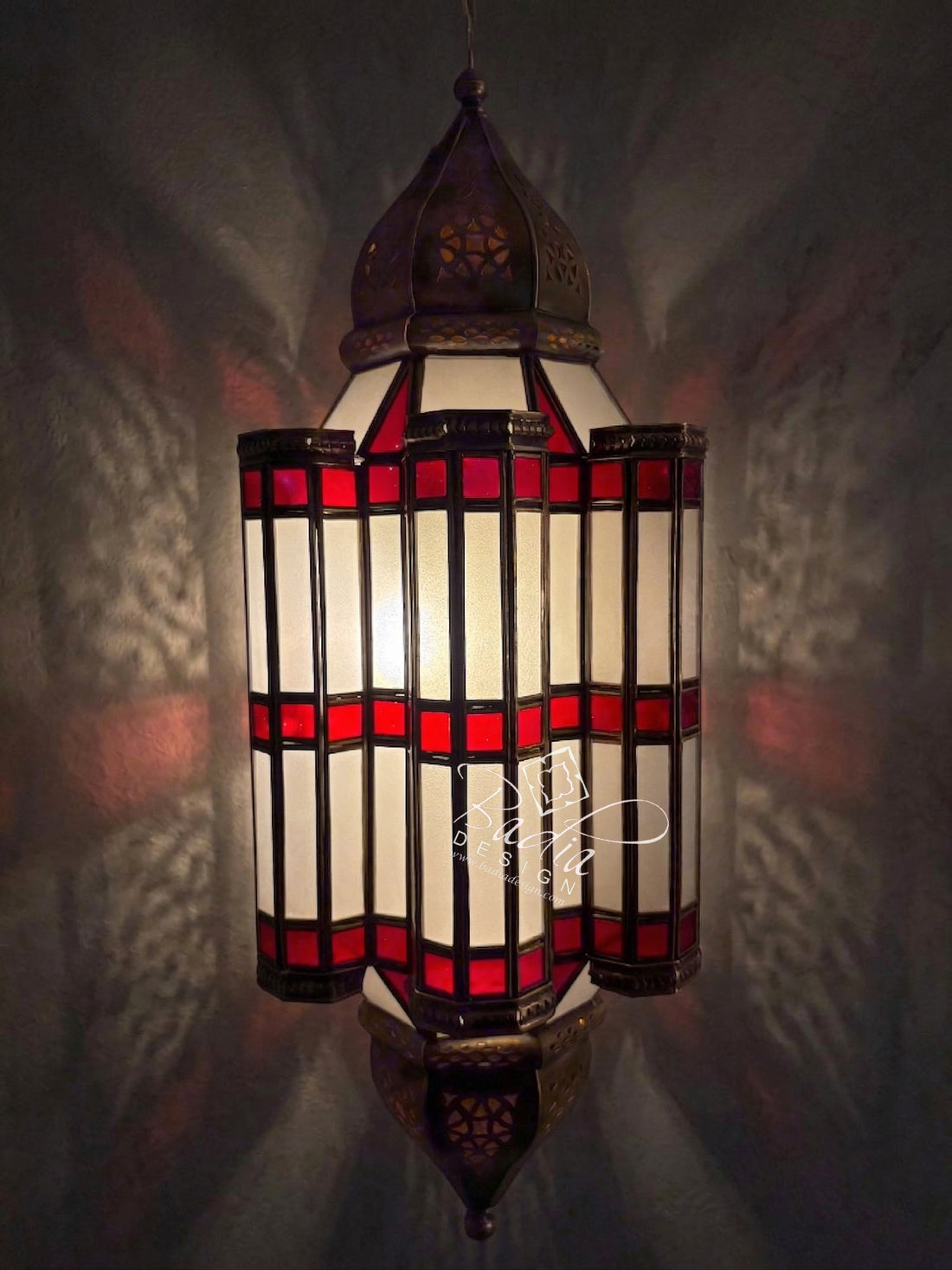 Decorative stained glass lamp with red and white design on a dark background