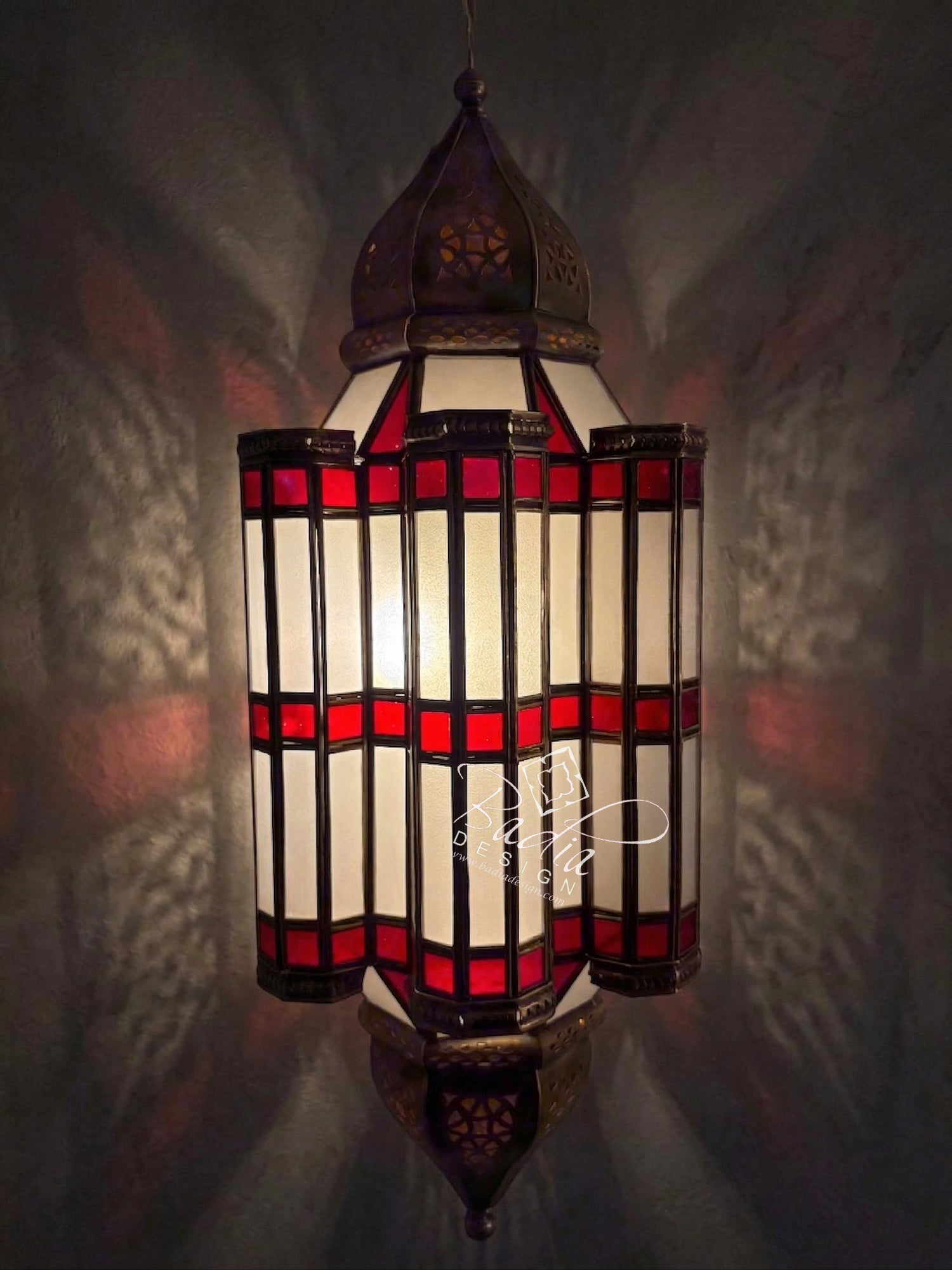 Decorative stained glass lamp with red and white design on a dark background