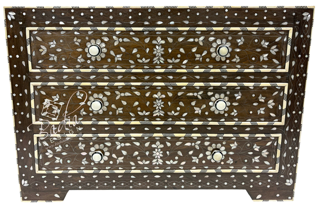 Wooden chest of drawers with intricate bone inlay patterns on a white background