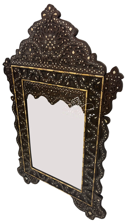 Decorative mirror with intricate dark brown frame on a white background
