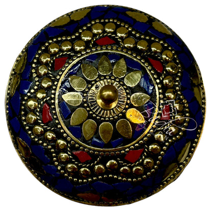 Decorative round container top with gold, blue, and red colors on a white background