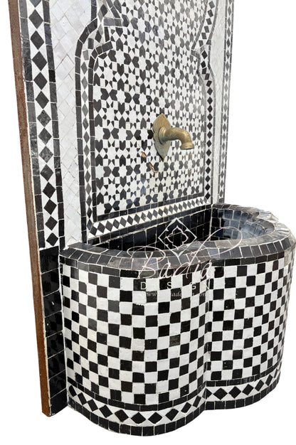 Black and white mosaic patterned water fountain with decorative design